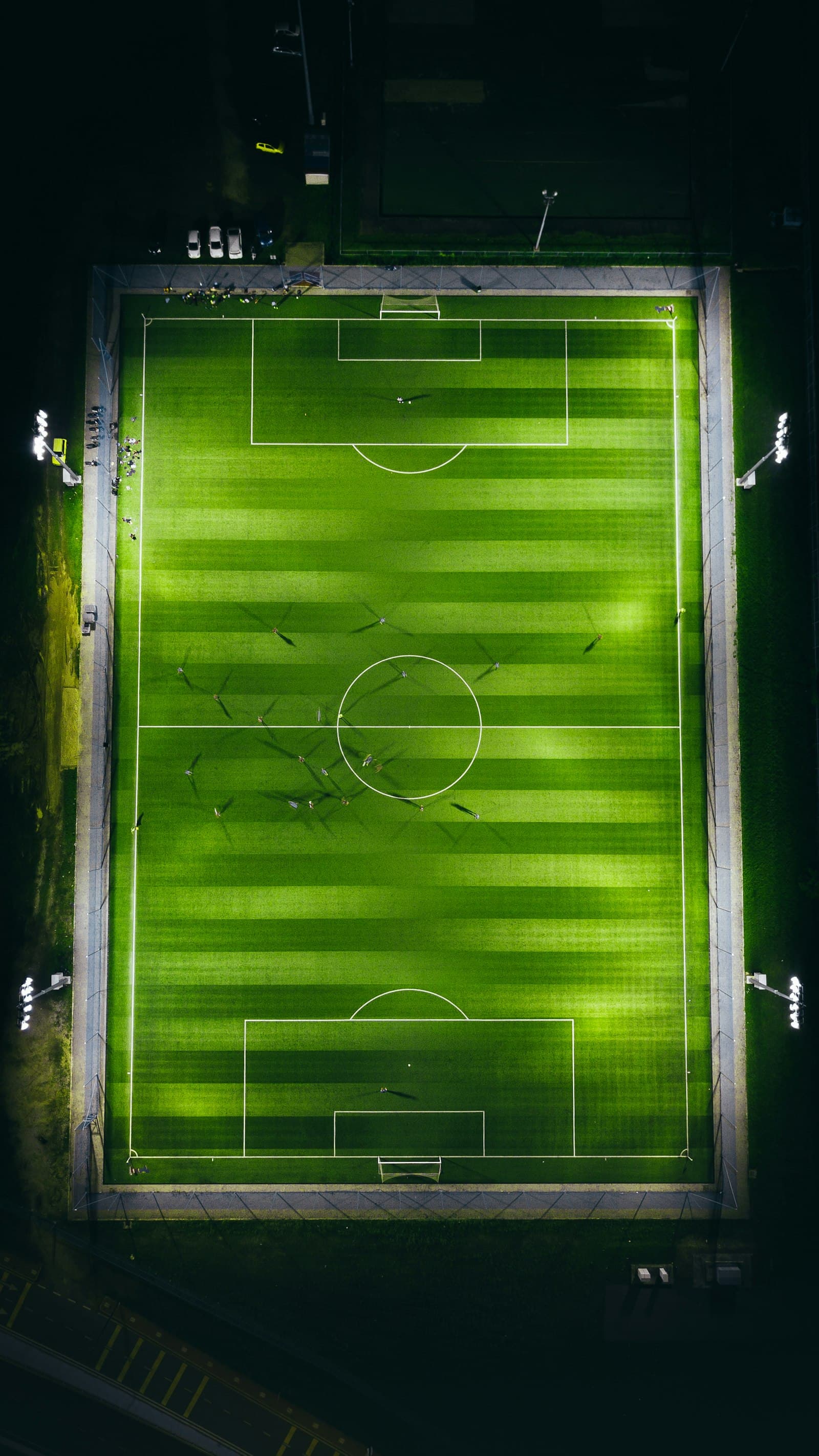 Cancha de fútbol iluminada de noche, vista aérea